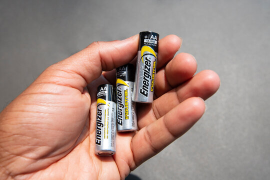 HAMILTON, Ontario, Canada - June 2021: A hand is holding three Energizer AA batteries.