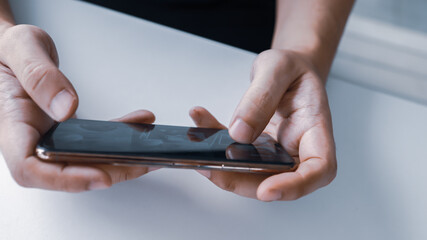 Man playing game on mobile phone. gamer boy playing video games holding Smartphone working mobile devices. cell telephone technology e-commerce concept
