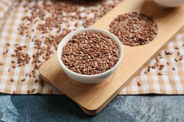 Bowl of flax seeds on color background, closeup