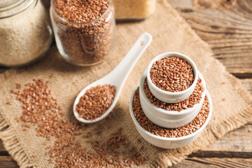 Composition with bowls of flax seeds on wooden table