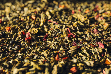 Dry green tea leaves as background, closeup