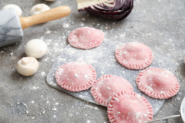 Board with raw ravioli on table