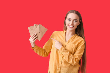 Young woman with letters on color background