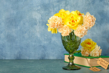 Composition with beautiful narcissus flowers, book and shopping tags on color background