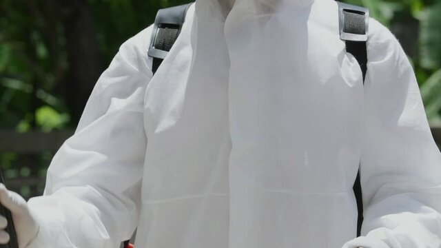 Close up Slow motion of a medical staff in PPE suit and face mask using disinfectant spray. Cleaning and sterilizing the prevent spread of Covid-19.