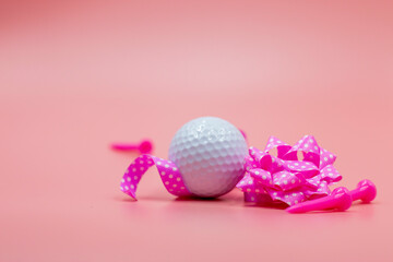 Golf ball with pink ribbon are on pink background