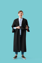 Obraz na płótnie Canvas Male graduating student on color background