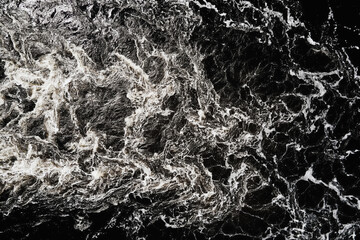 Waves of water in the river with whirlpool, aerial view. Water background. Abstract pattern of water waves