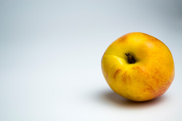 One nectarine lies on a monochrome background. Dietic protact, a product of ancient people.