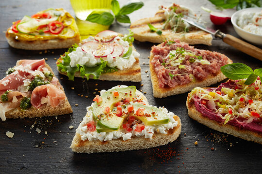 Tasty assorted open sandwiches on table