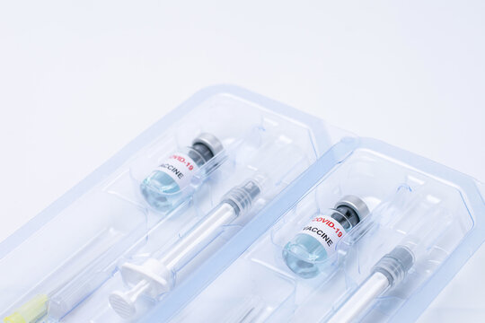 Covid-19, Flu, Coronavirus Liquid Vaccine Vial Bottle And Syringe Set In Plastic Package Container Preparing For Injection On White Background. Vaccination For Fight Covid-19 Virus Concept.