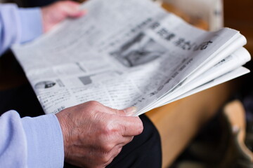 新聞を読むシニア女性