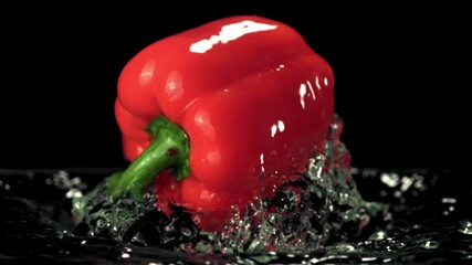 Super slow motion in the water with splashes floats one red bell pepper. On a black background. Filmed on a high-speed camera at 1000 fps. - Powered by Adobe