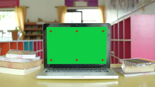 Chroma key green screen laptop computer set up for work at school.