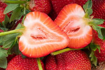 Red Strawberries in wooden bowl on wooden table, Fresh long stem berries, Organic Strawberry in Bamboo basket.