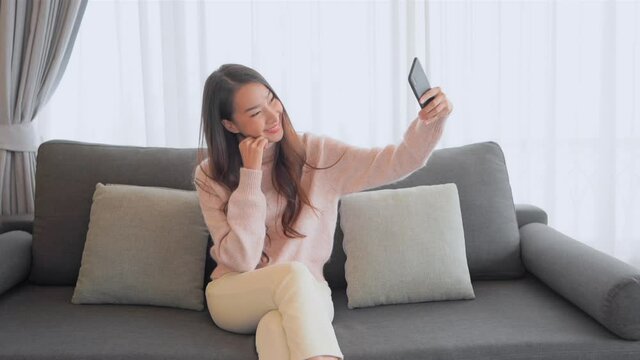 A pretty young woman searches for the best angle for her new selfie.