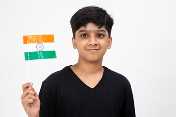 Young Indian boy proudly holds the tricolour Indian flag. Teenager holding national flag