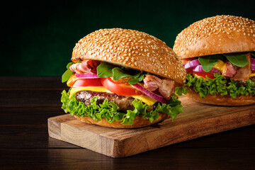 Two fresh homemade tasty burgers on green background. Fast food concept.