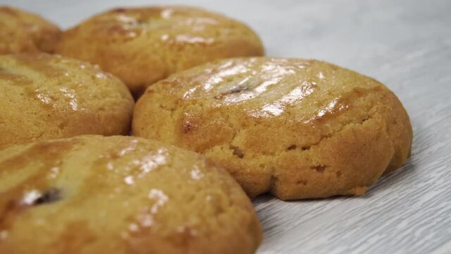 Stacked round fresh shortbread cookies on a wooden surface close-up. Rotating dessert