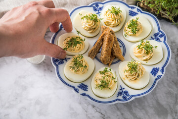 Kalte gefüllte russische Eier mit Frischkäse, Kresse und Kräuter farciert auf Blau Weiß...