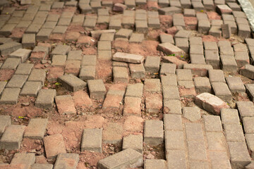 Broken paving stones on the road. The masonry is broken.