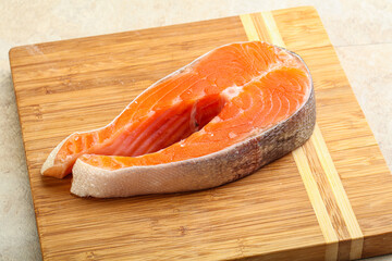 Raw salmon steak over board