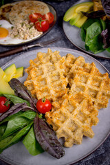 Waffles with salad, avocado and tomatoes, Top view breakfast on a dark background