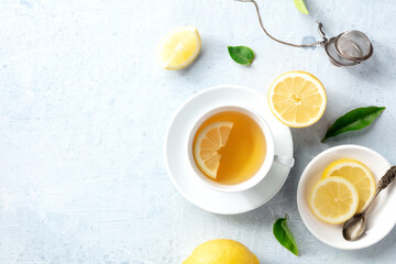 Lemon tea in a cup, shot from the top with copy space. Organic lemons, green leaves and the natural...