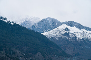 a view of vashisht manali temple with snow mountains