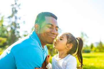 latin hispanic man with cute baby celebrating father's day at picnic in sunny park