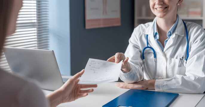 Smiling doctor giving a prescription to a patient