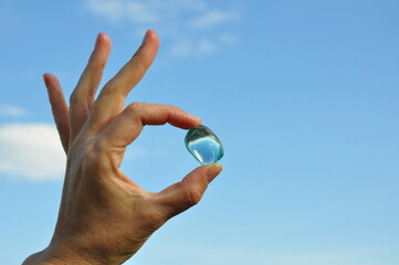 Gem in hand against the background of the sky
