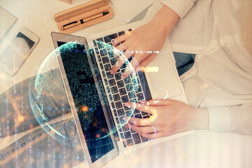 Double exposure of woman hands working on computer and world map hologram drawing. Top View. International business concept.