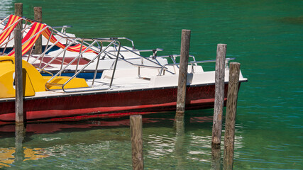 Fototapeta na wymiar Treetbote auf einem türkisblauen See - Urlaubsfeeling - Tretbootverleih