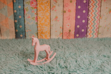 A backdrop for a toddlers photo session in a photo studio with a pink rocking horse