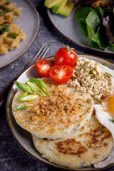 Potato pancakes with salad, avocado and tomatoes, Top view breakfast on a dark background