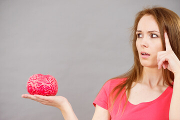 Woman thinking holds brain