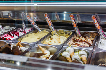 Bancone di una gelateria con diversi tipi di gusti di gelato