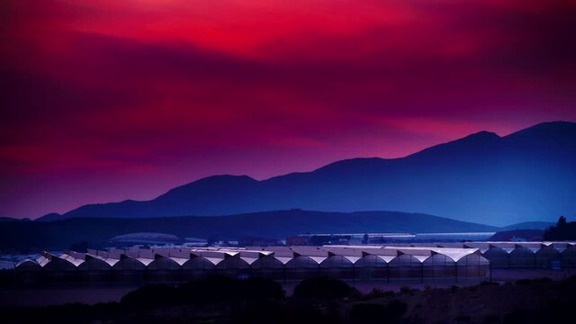 Spanish sunset landscape with many commercial greenhouses. Industrial agriculture.  Mediterranean region of Mazarron, Sierra de las Moreras in Murcia Spain. Timelapse