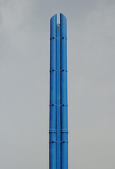 Tall Blue Painted Industrial Steel Chimney against Clear Sky