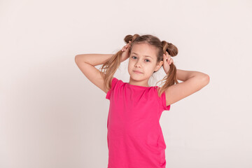 happy child on a white background. a girl in a pink T-shirt and pants.