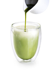 Pouring green matcha into glass with milk and ice isolated on white background.