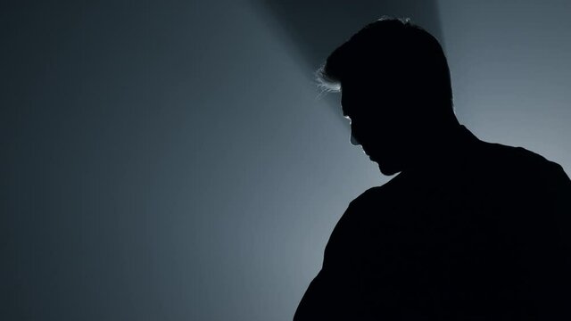 Silhouette cruel killer stabbing with knife indoors. Risky man attacking weapon