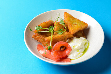 Closeup of freshly fried potato pancakes served with salmon fish and sauce.