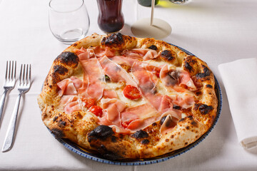 Pizza napoletana con mozzarella, crema di noci, speck, pomodori e basilico