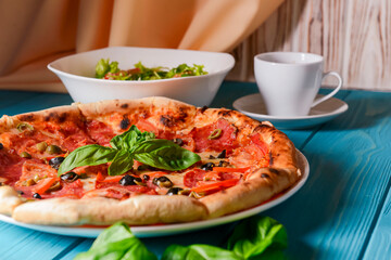 Fresh italian pizza with salami and black olives. Traditional Italian pizza recipe, Italian cuisine.