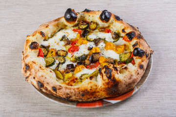 Pizza napoletana con pomodori, zucchine, peperoni, melanzane e mozzarella