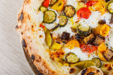 Pizza napoletana con pomodori, zucchine, peperoni, melanzane e mozzarella