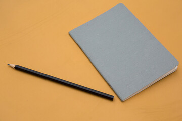 Photo of pencil and notebook on the leather background 