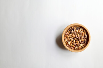 Top Views of Tiger Nuts or Queen Nuts in a wooden bowl isolated on white background, Healthy Food Concept.